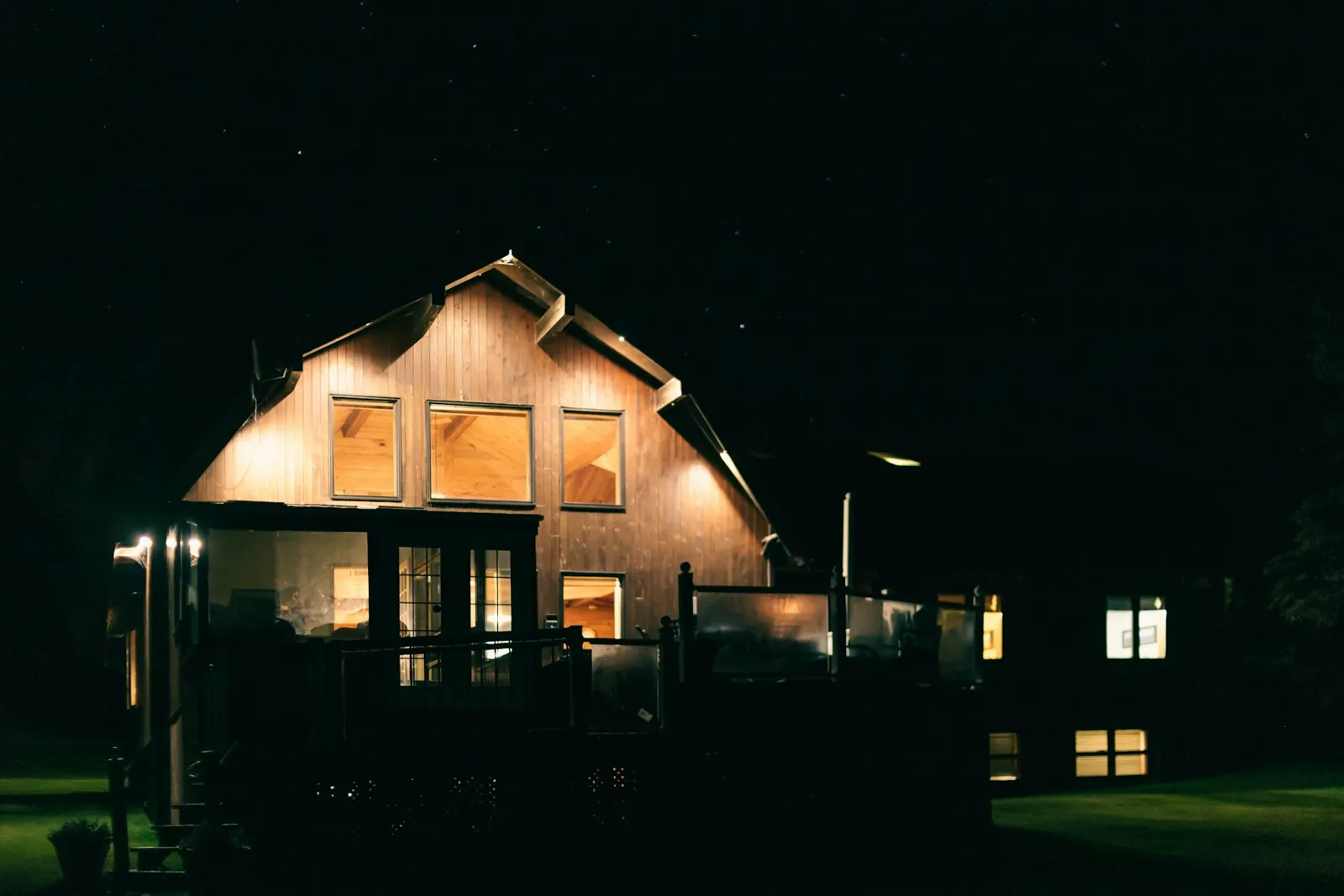 House at night with warm exterior and window lighting